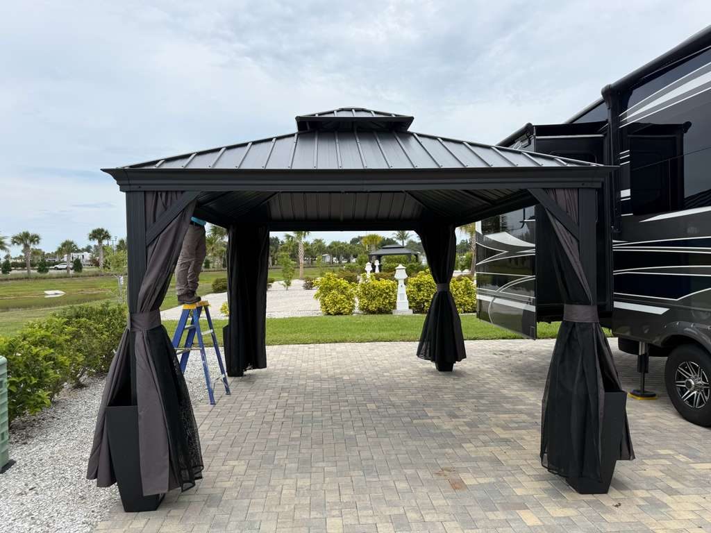 Hardtop gazebo installed on a paver patio next to an RV