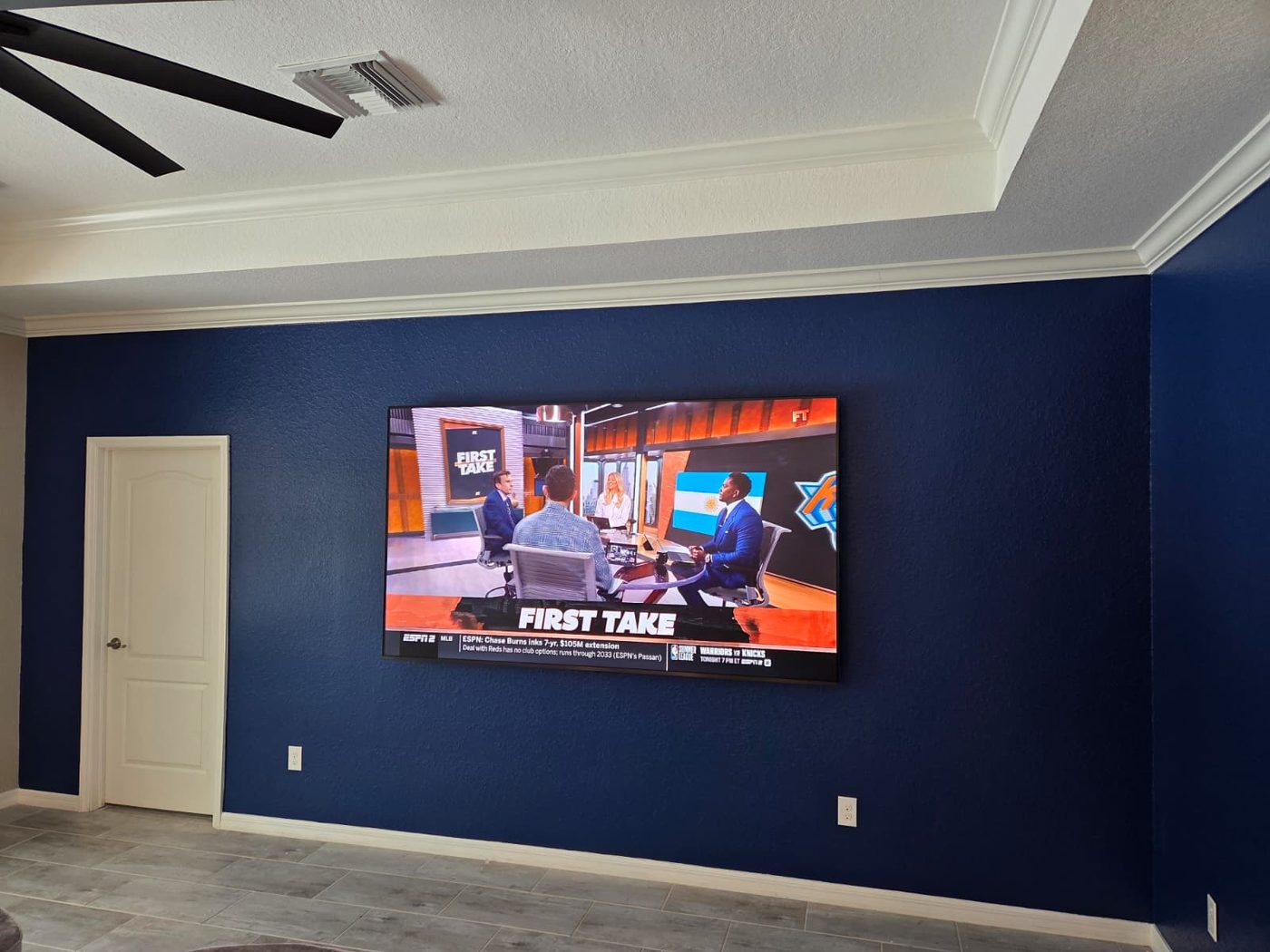 Wall-mounted TV on navy wall
